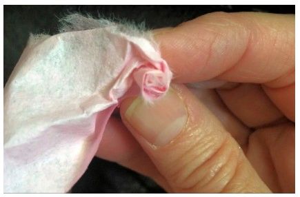Strip of coffee filter ready to be rolled into a rose