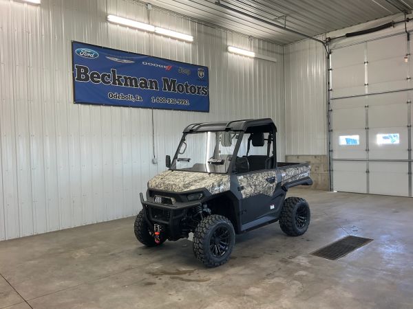 Camouflaged utility vehicle parked inside a Beckman Motors garage.