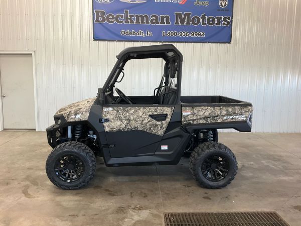 Camouflaged off-road utility vehicle inside a showroom.