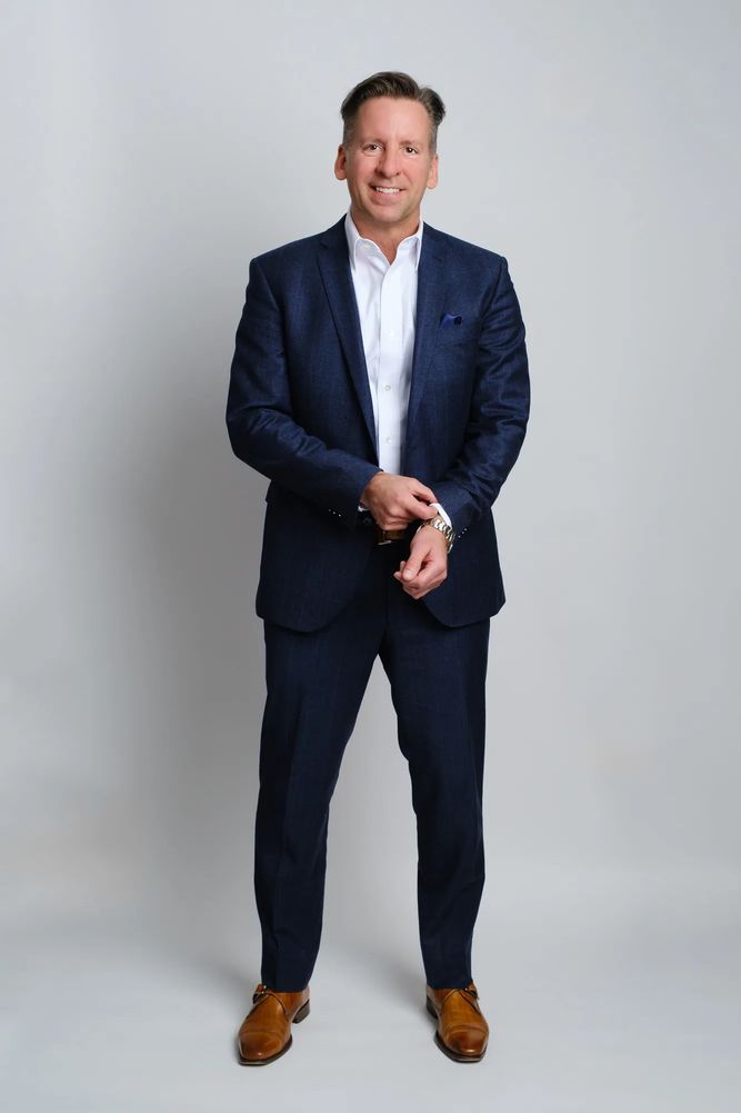 David Carr, executive and investor, standing in a professional portrait.