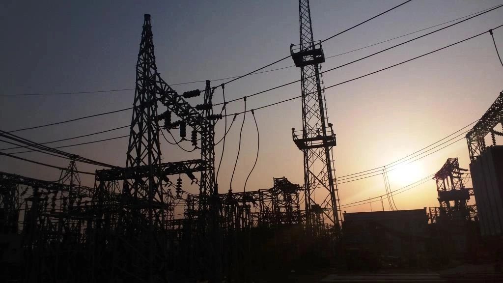 Electric power substation silhouetted against a setting sun.
