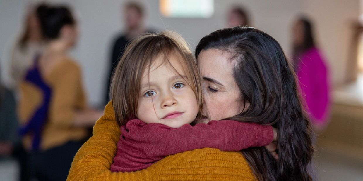 Woman hugging a child in a warm embrace.