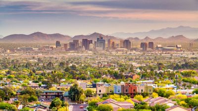 City skyline with mountains in the background at sunset.