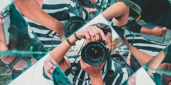 Photographer taking a picture through a fragmented mirror.