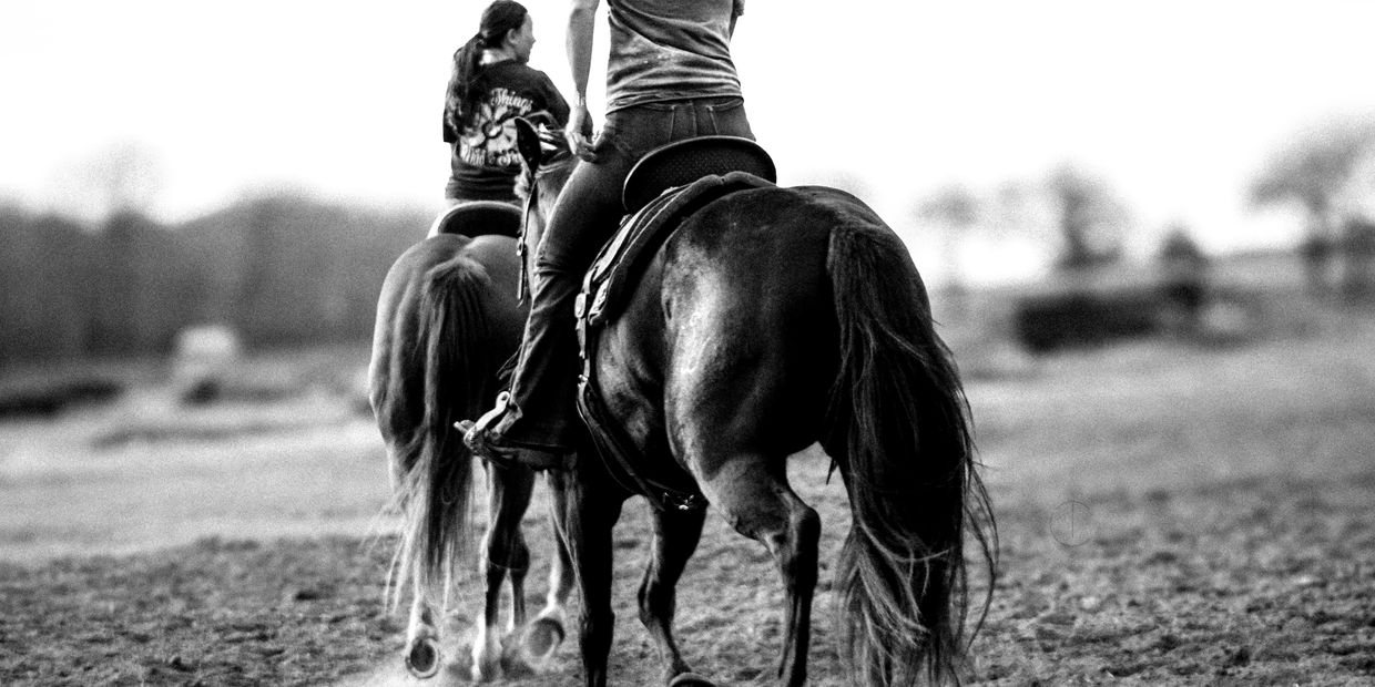 Alexis McQuarie riding a bay mare in the warm up pen in Stephenville, Texas