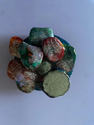 A cluster of colorful, glittery stones on a plain surface.