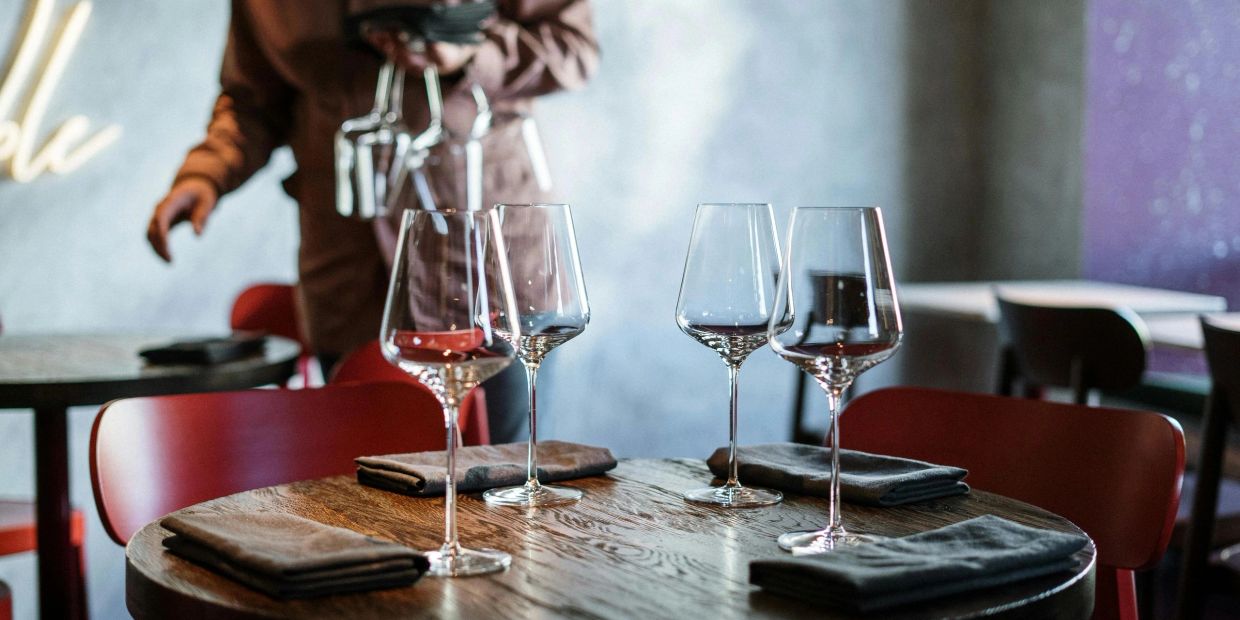 Four wine glasses on a wooden table.