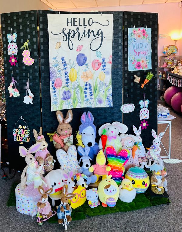 Colorful spring and Easter-themed plush toys and decorations with floral banners.