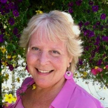A picture of Nanci, a white woman with blonde hair, smiling at the camera.