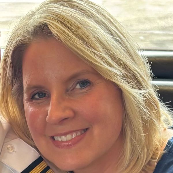 Smiling blonde woman with blue eyes.