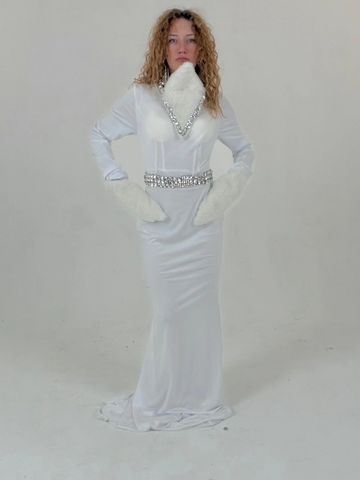Woman in a sleek white gown with fur accents and silver chain details.