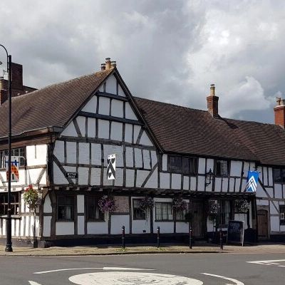 Historic Tudor-style black and white timber-framed building on a street corner.