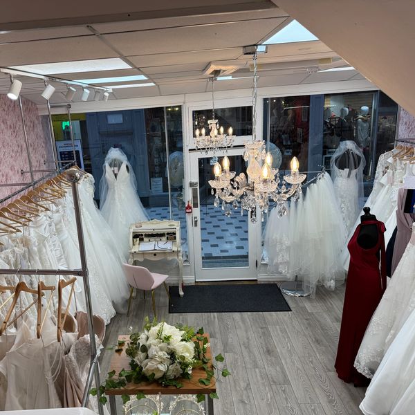 Elegant bridal boutique with wedding gowns and a chandelier.