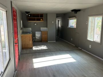 Empty room with gray walls and wooden cabinets.