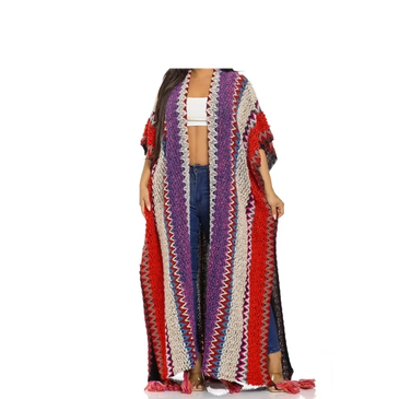Woman wearing long colorful crocheted cardigan with tassels.