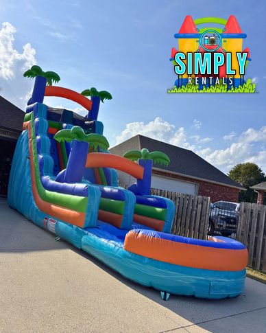 Large inflatable water slide with palm tree decorations.