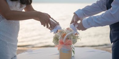 Newly Wed pouring sand into one shared jar from two seperate jars. To signifying the joining of love.