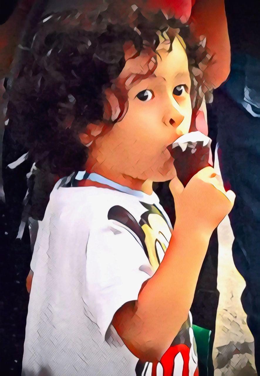 Child enjoying a chocolate ice cream cone.