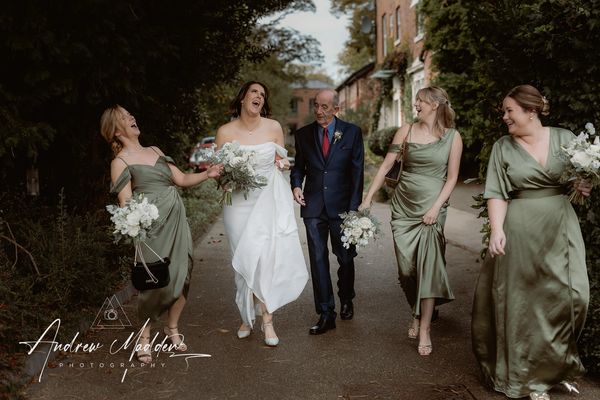 Bridal party laughing as they walk to ceremony for Didsbury House wedding, Manchester
