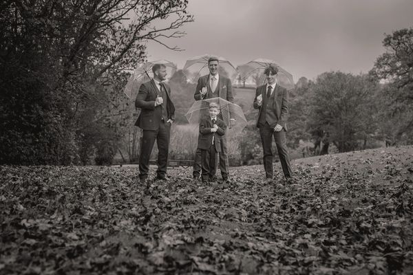 Groom's party walk in the rain at The White Hart Inn, Alfreton Derbyshire