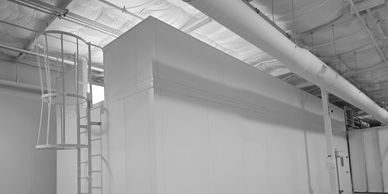 Industrial white structure with a spiral staircase inside a large facility.