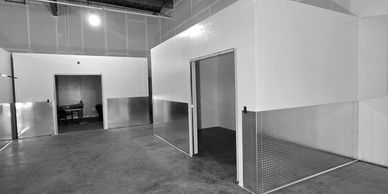 Interior of an industrial warehouse with white partition walls and metal panels.