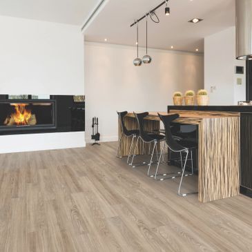 Modern dining area with fireplace and wooden floors.