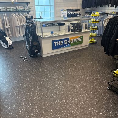 Golf merchandise store interior with clubs, balls, and apparel.