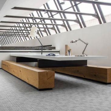 Modern office workspace with wooden benches and sleek lighting.