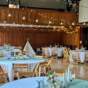 Event venue with round tables and string lights.