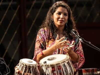 Woman playing tabla during a performance.