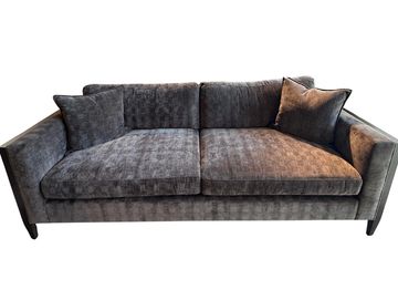 Modern dark gray fabric sofa with two cushions.