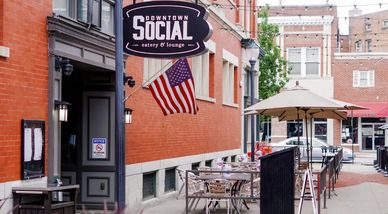 Outdoor seating area at Downtown Social eatery with American flag.
