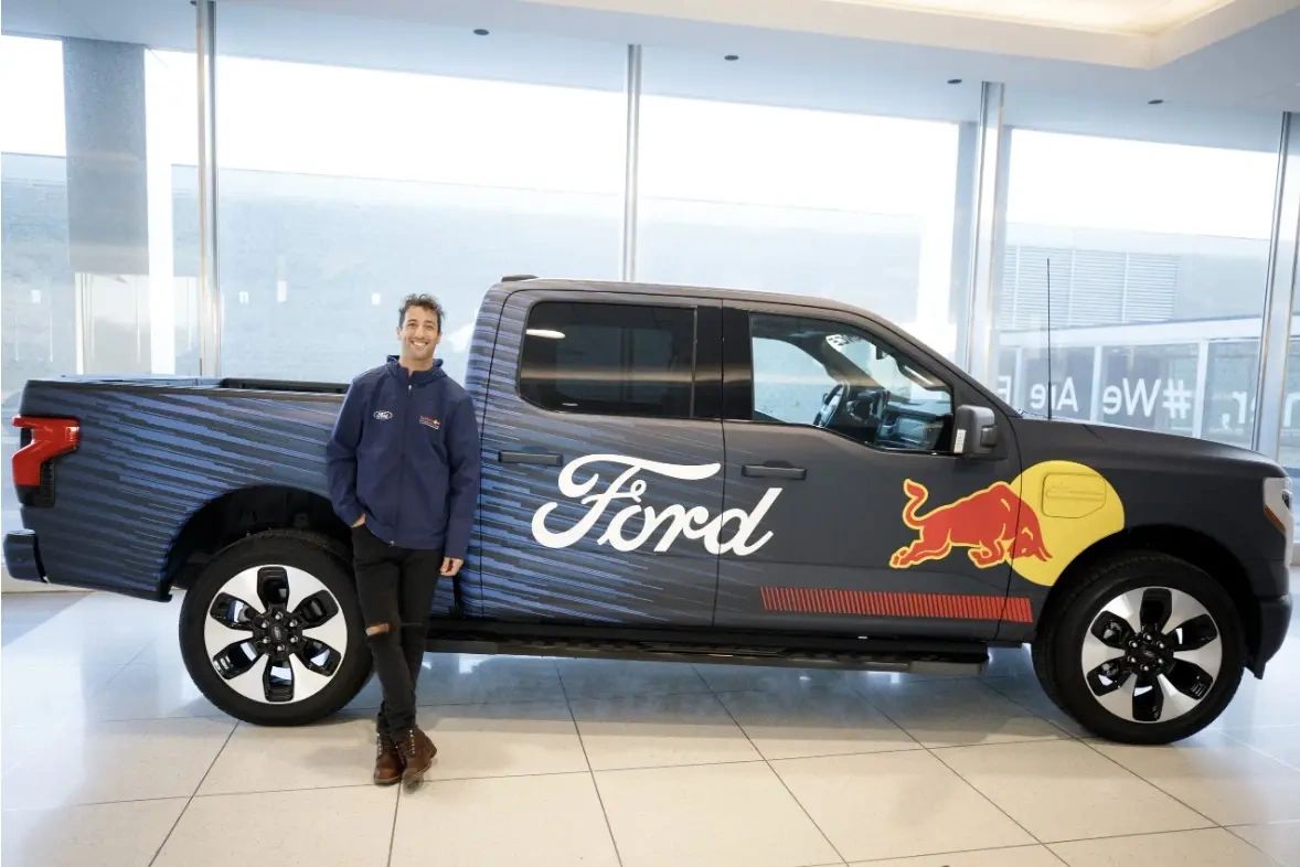 Daniel Ricciardo stands alongside a Ford pickup featuring Red Bull branding during Ford’s 2023 announcement of its Formula 1 return in partnership with Red Bull. 📸 Charlotte Smith / Ford Motor Co.