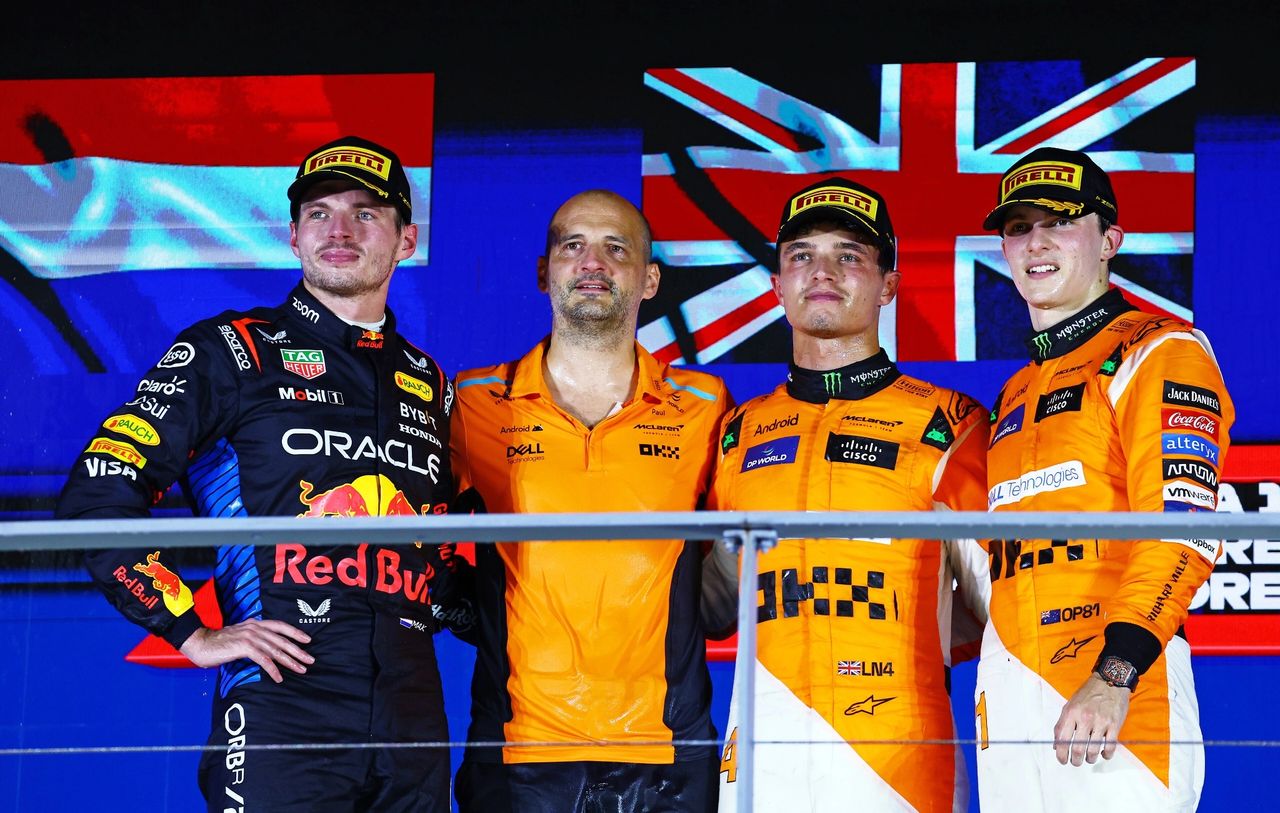 Lando Norris of McLaren celebrates victory at the 2024 Formula 1 Singapore Grand Prix, joined on the podium by Red Bull’s Max Verstappen in second and teammate Oscar Piastri in third. A night of triumph for McLaren under the lights at Marina Bay.