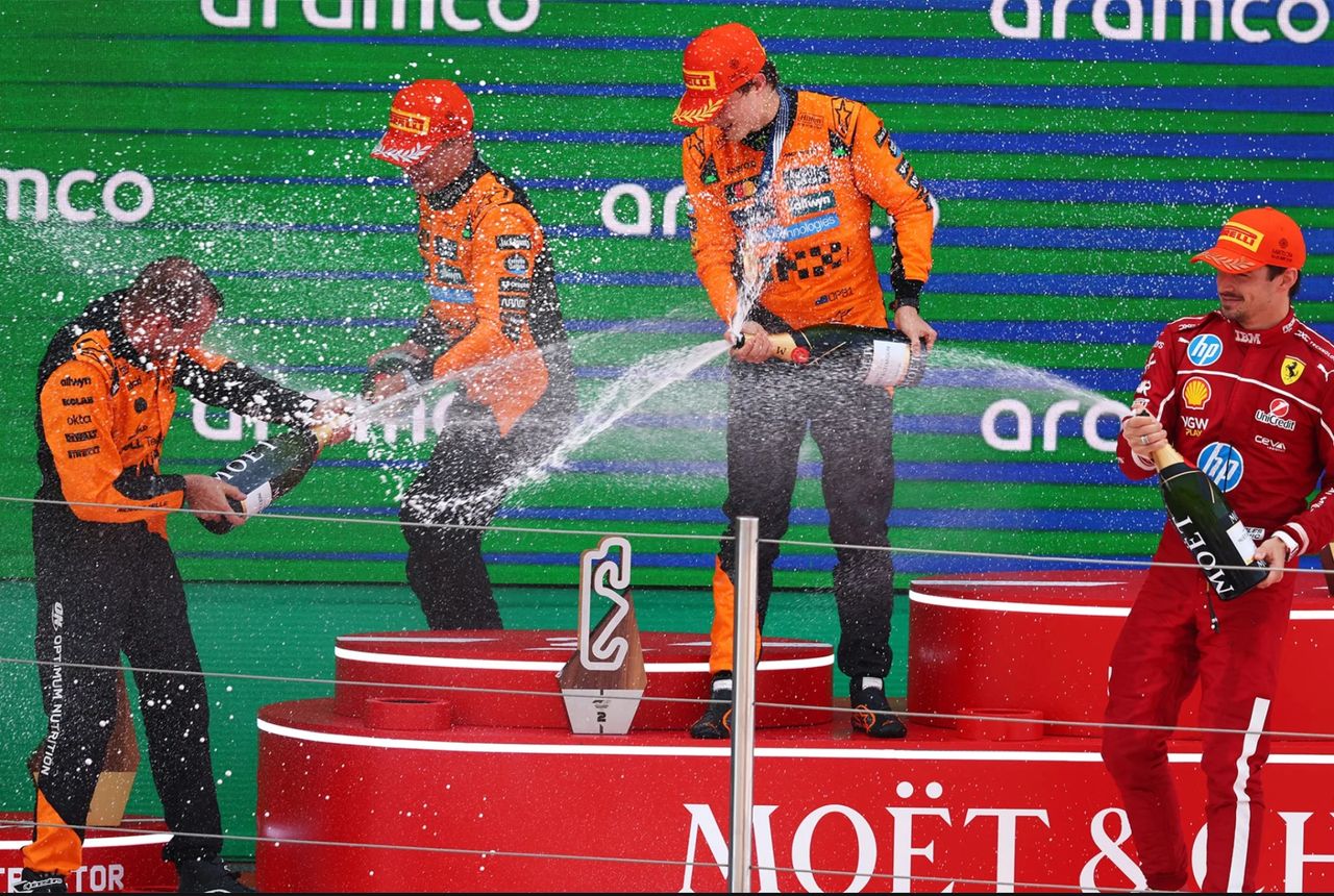 McLaren's Oscar Piastri and Lando Norris celebrate a dominant 1–2 finish at the 2025 Spanish Grand Prix, with Ferrari’s Charles Leclerc completing the podium. McLaren's Oscar Piastri and Lando Norris celebrate a dominant 1–2 finish at the 2025 Spanish Grand Prix, with Ferrari’s Charles Leclerc completing the podium.