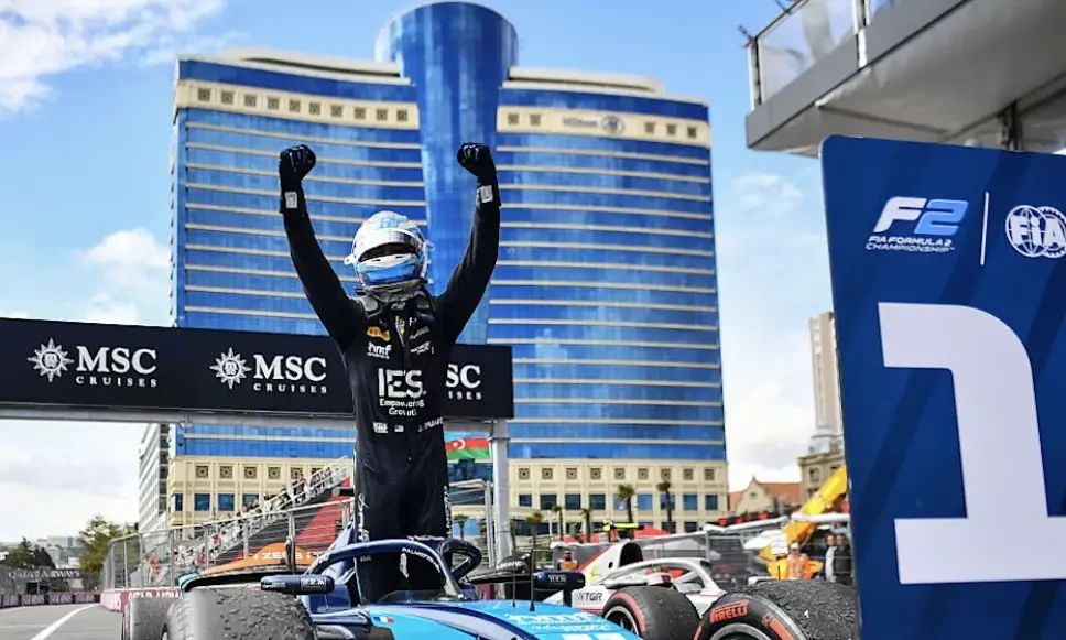 Jak Crawford celebrates F2 Baku Feature Race victory 2025, standing on his car with arms raised after holding off Joshua Duerksen