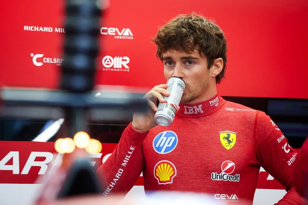 Charles Leclerc drinking from a can in the Ferrari garage during the 2025 Dutch Grand Prix, reflecting tifosi pressure ahead of Monza