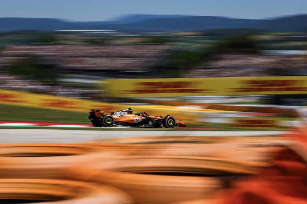 Oscar Piastri powers through Sector 3 at the CircuitMcLaren F1 car driven by Oscar Piastri speeds through Barcelona track during 2025 Spanish GP practice. Blurred background highlights car’s motion.