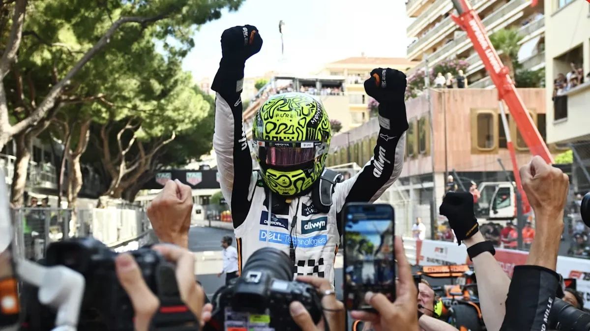 Lando Norris in McLaren race suit and helmet raising both fists in celebration after winning the 2025 Monaco Grand Prix surrounded by photographers and team members on the Monte Carlo street circuit. Lando Norris in McLaren race suit and helmet raising both fists in celebration after winning the 2025 Monaco Grand Prix surrounded by photographers and team members on the Monte Carlo street circuit.