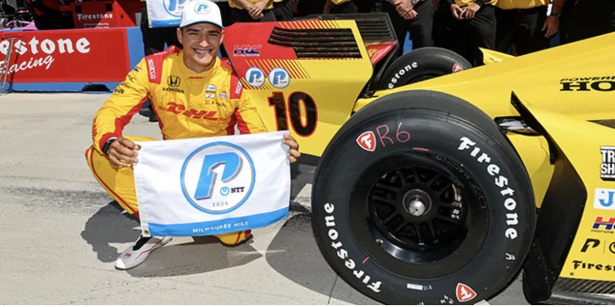 Alex Palou celebrates Milwaukee pole with the NTT P1 Award flag beside his No. 10 DHL Honda at the Milwaukee Mile, August 23, 2025.fter taking pole for the Milwaukee Mile 250. (Photo: INDYCAR)