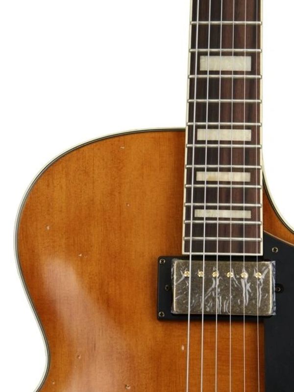 Close-up of a vintage electric guitar body and neck with strings.