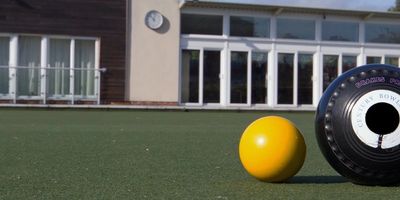 A bowl and a jack on a lawn bowls green