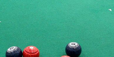 Several bowls and a mat on a bowling green