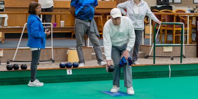 A bowls player about to deliver his bowl