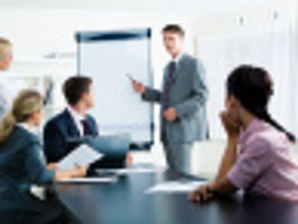 Business team in a meeting with a presenter using a flip chart.