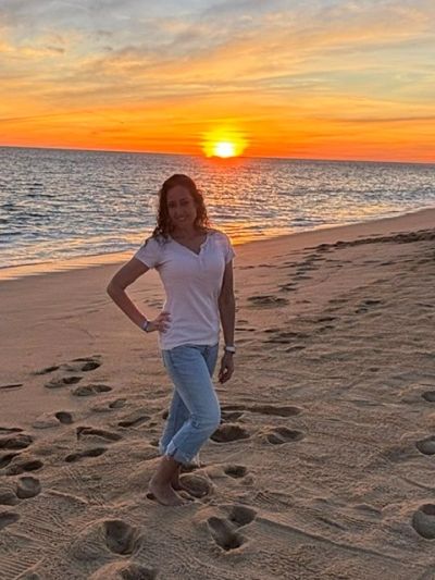 Woman posing on beach at sunset.