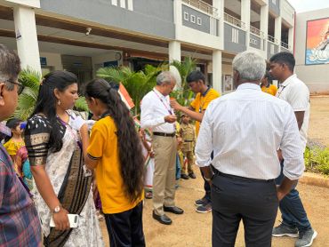 Group of people gathered outside a building, interacting.