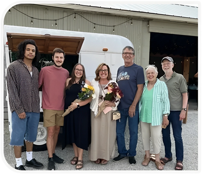 Family group posing by a white camper