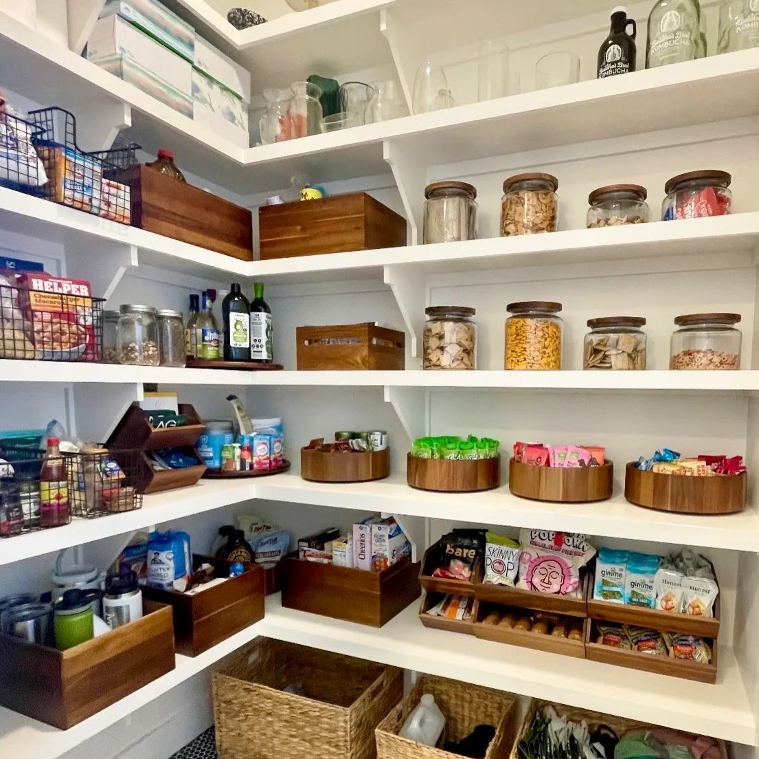 Organized pantry with shelves, jars, and baskets.